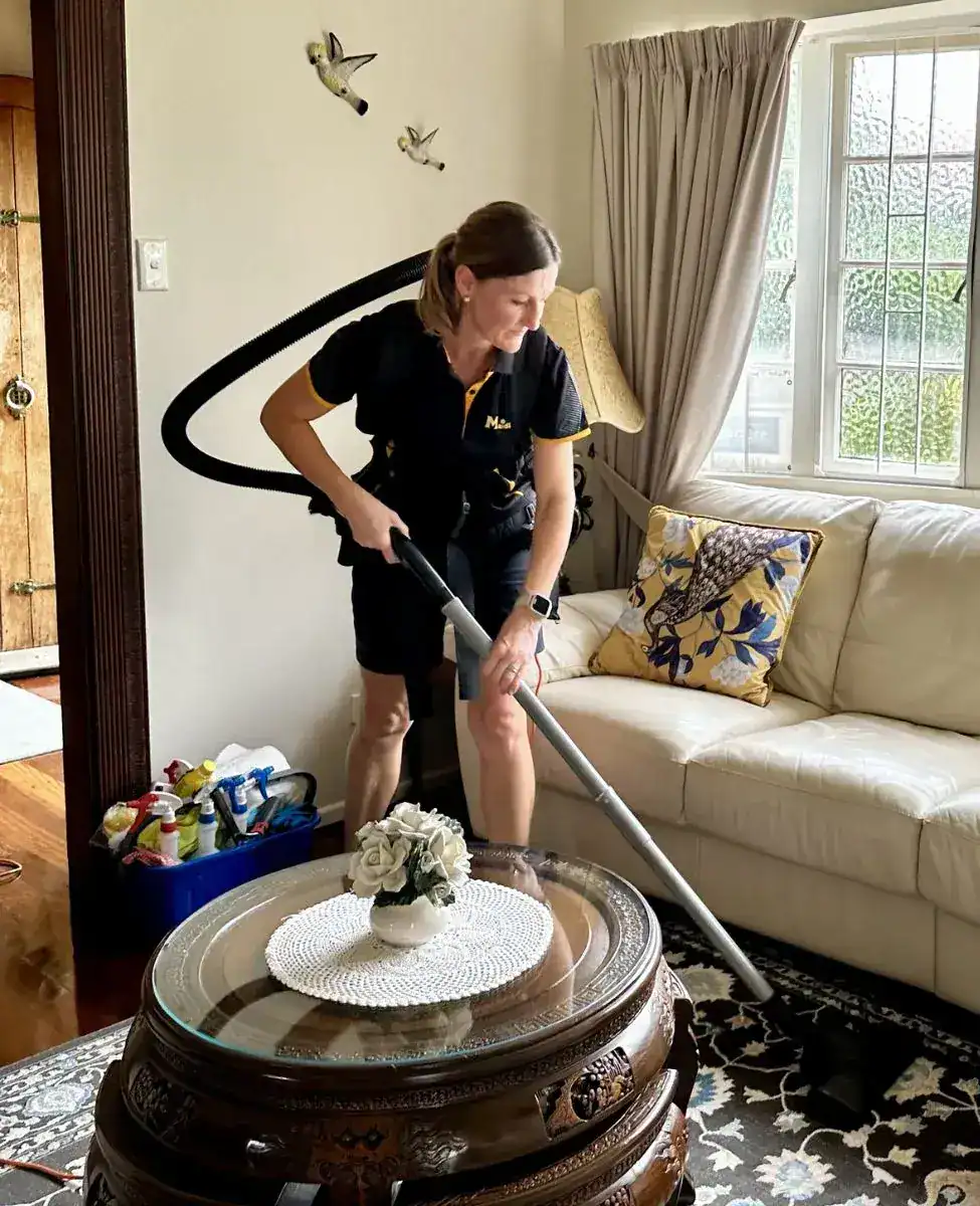Cleaner working through a living room